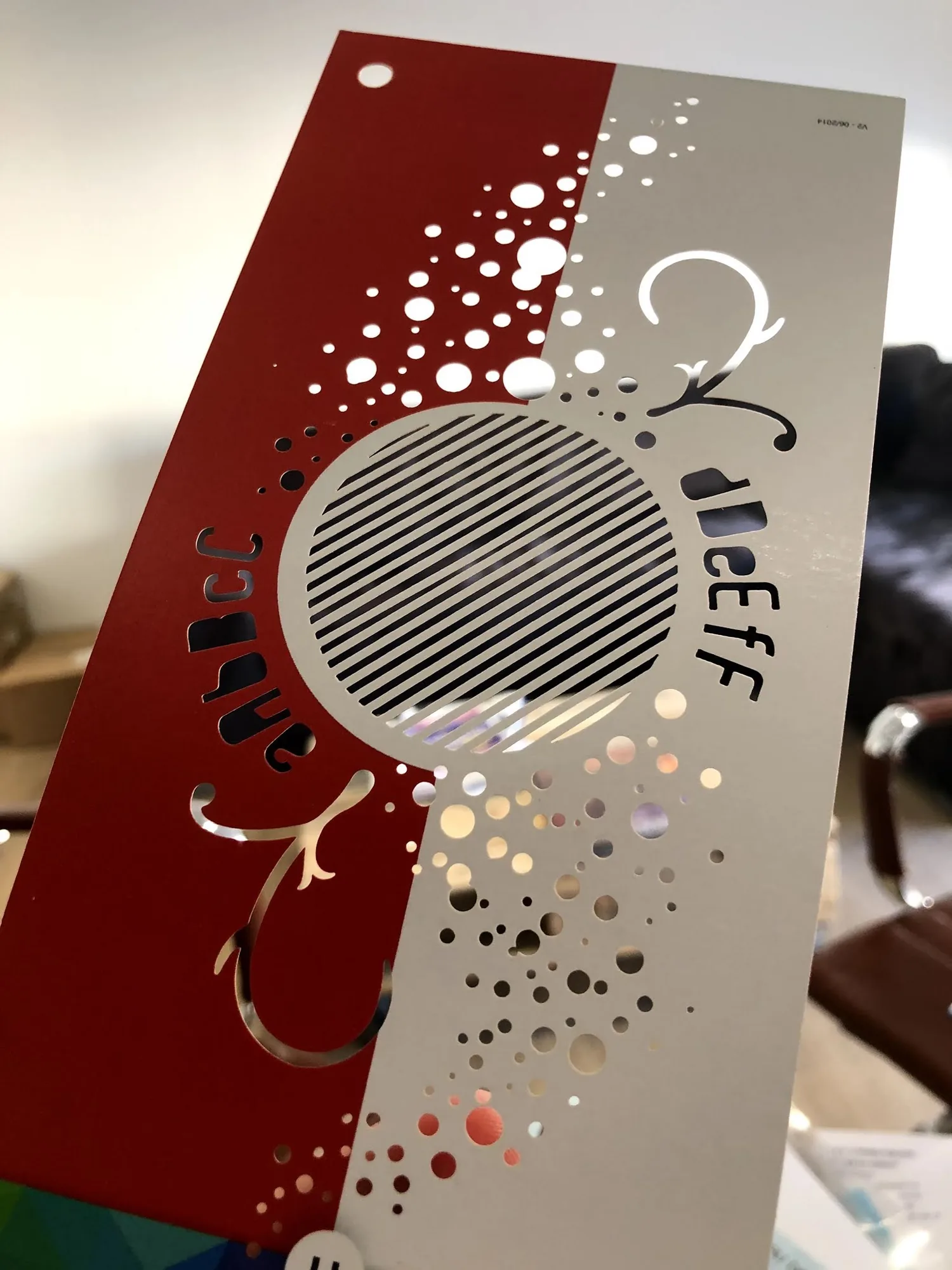 Carte rouge et argent découpée au laser, motifs de cercles et d'arabesques ajourés